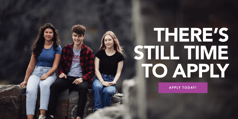 Three smiling students sitting outdoors on a rock, next to the text 'There’s still time to apply' and a purple 'Apply Today!' button